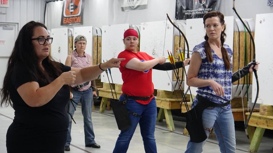 An instructor teaches archers at a Demmer Center class