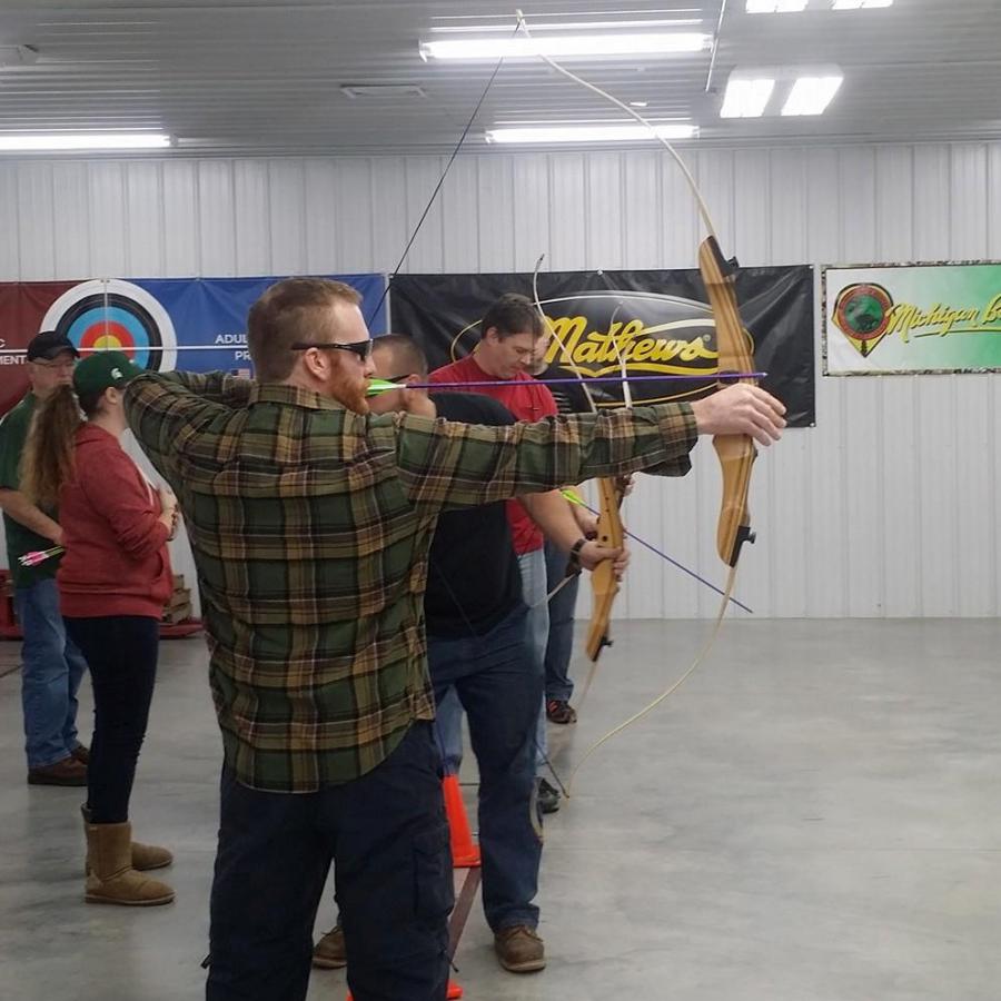 Archers draw back their bows at Demmer Center indoor range