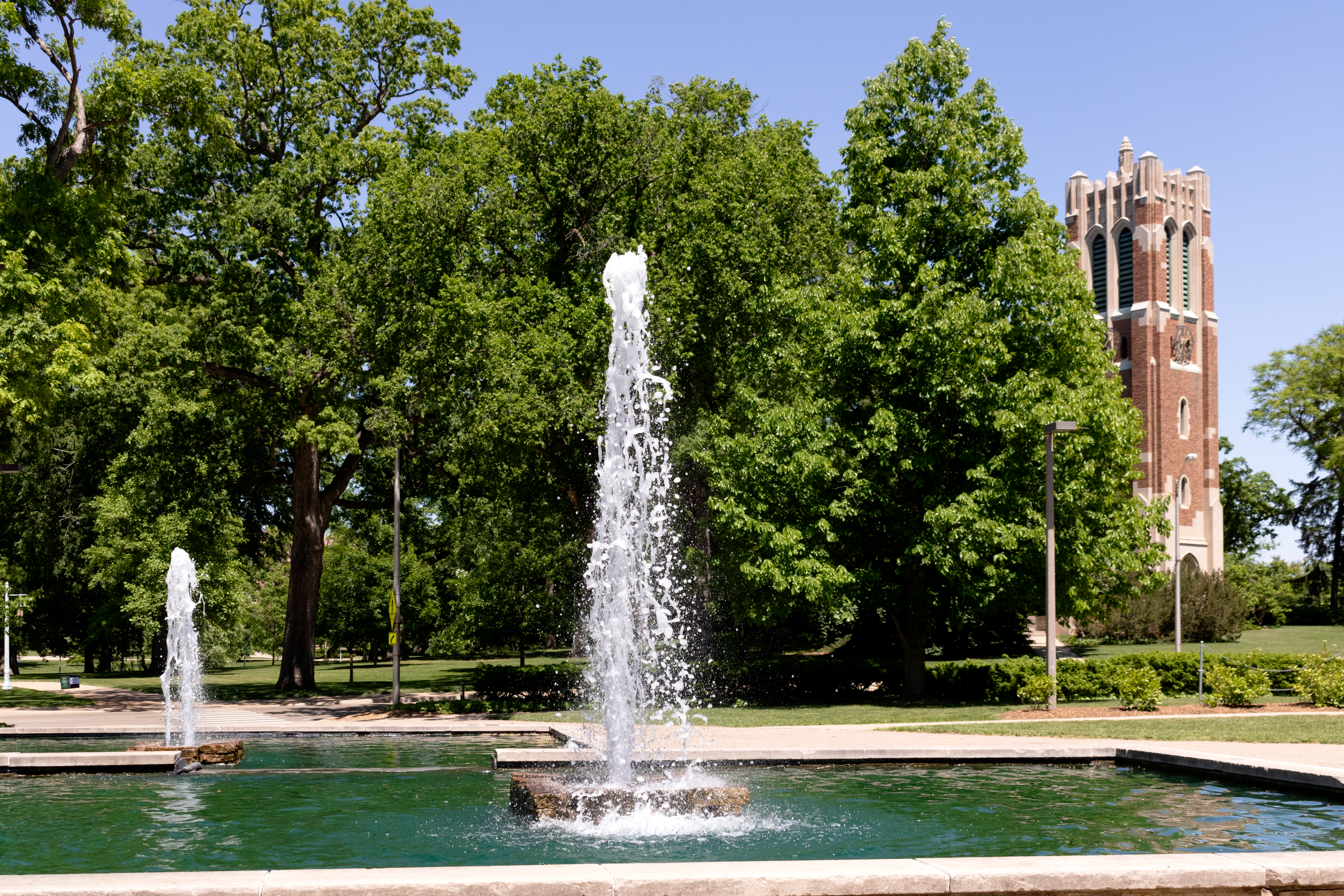 Image of the MSU Library fountains on a summer day with Beaumont Tower and trees in the background.
