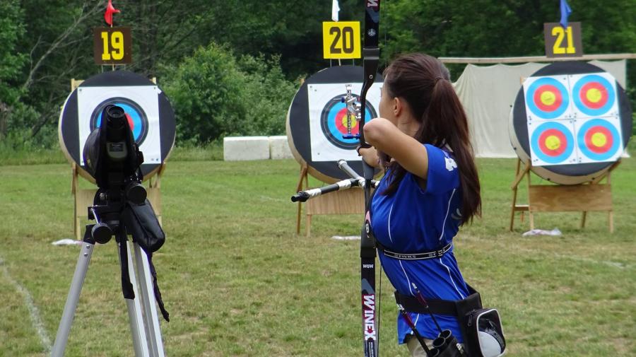 An archer aims downrange at a target, Demmer Center.