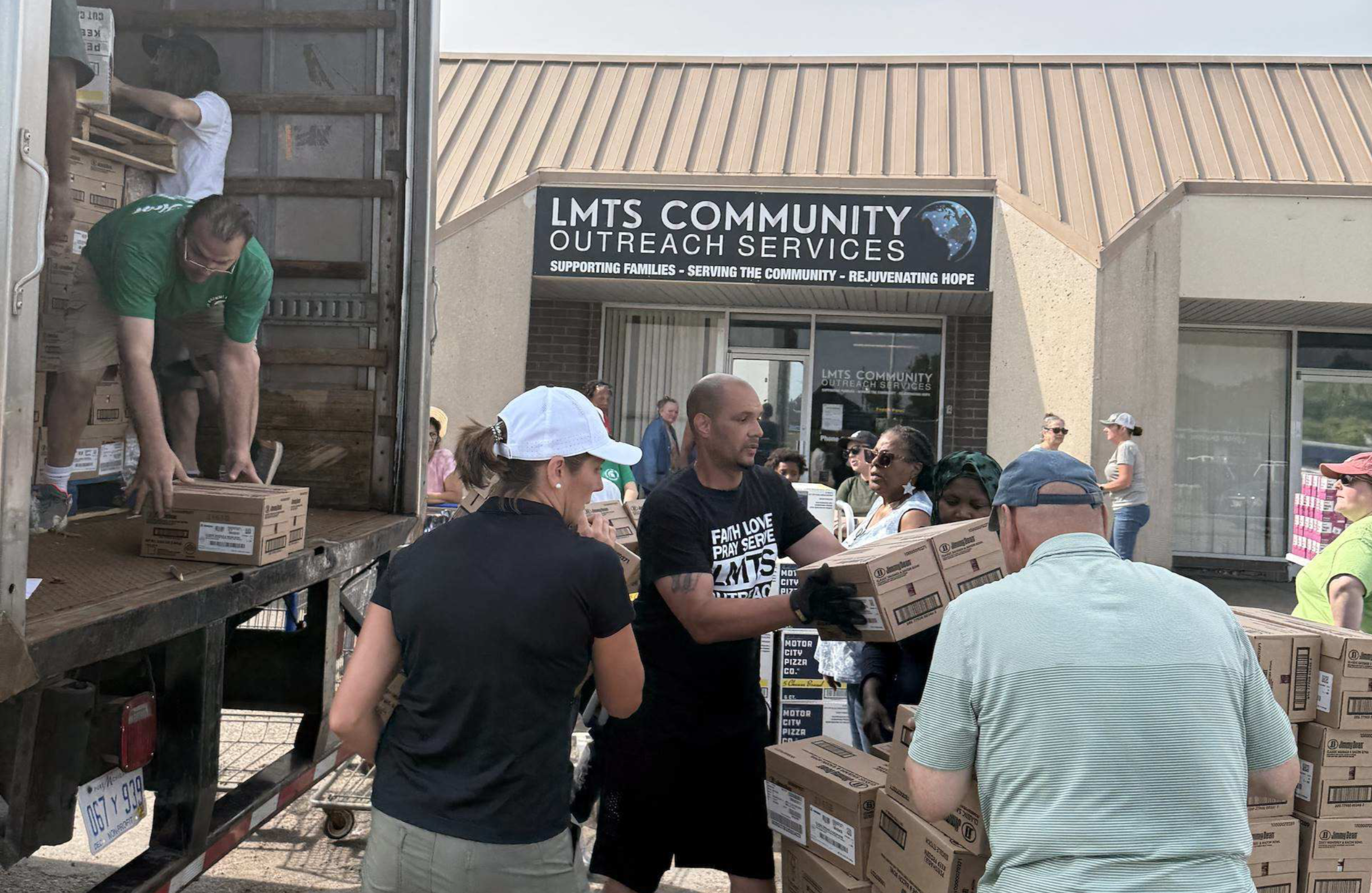 Team members unload boxes while setting up for a Fresh Food Friday event at LMTS Community Outreach Services.