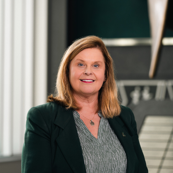 Professional headshot of Patricia A. R. Martinez, associate vice president for Residential and Hospitality Services at Michigan State University, wearing a green jacket and smiling indoors.