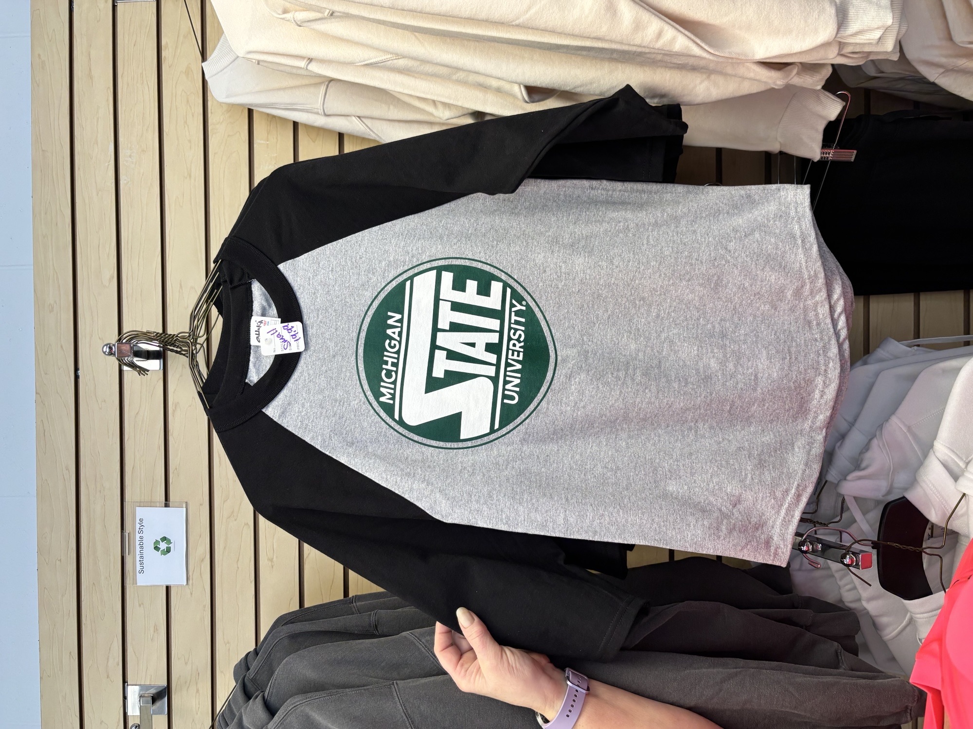 A black and gray baseball style shirt for $19.99 at Spartan Linen Services.