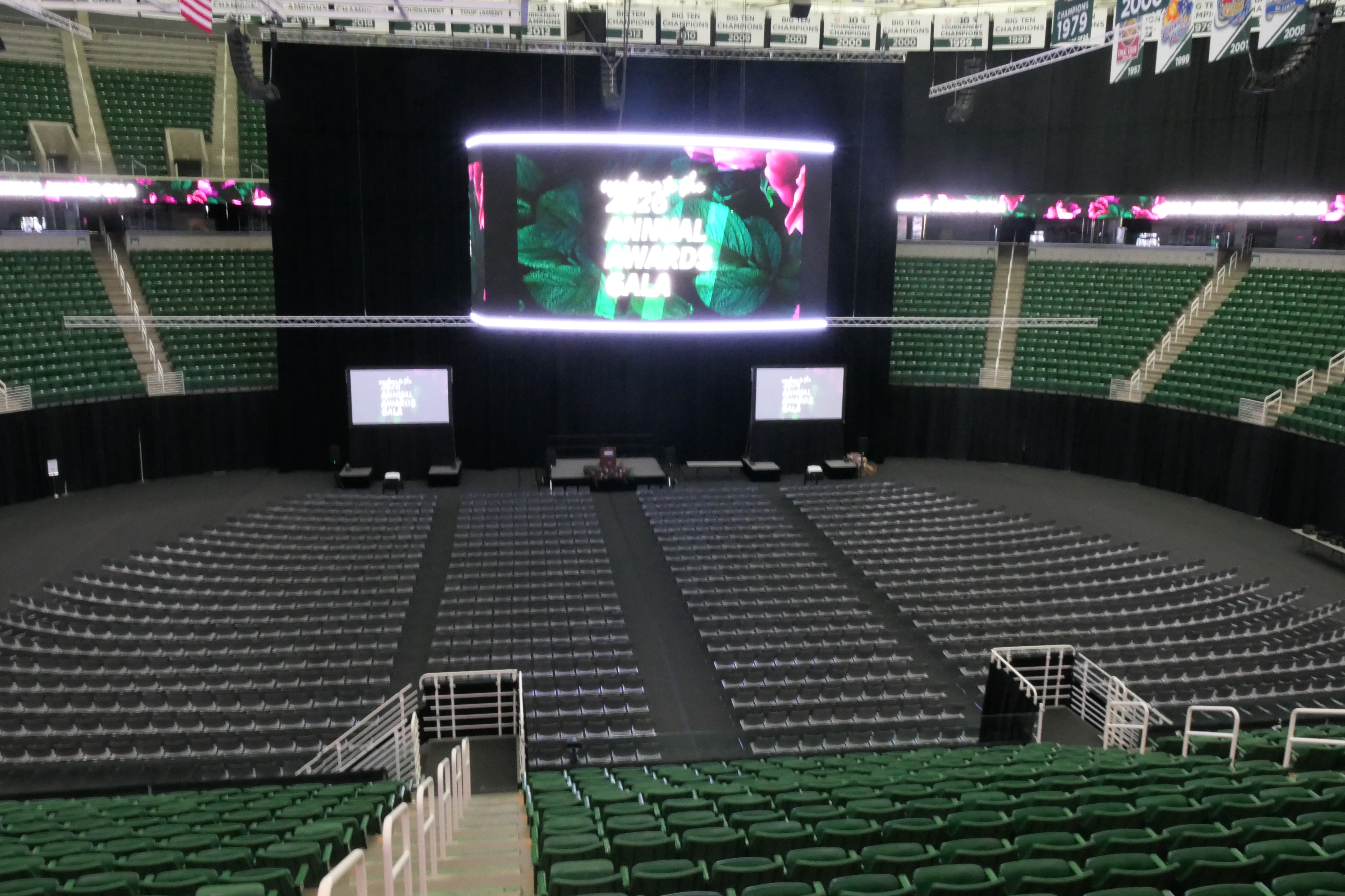 The floor of the Breslin Center laid out for the MSUFCU annual banquet with rows of seating and audio video displays from the stage.