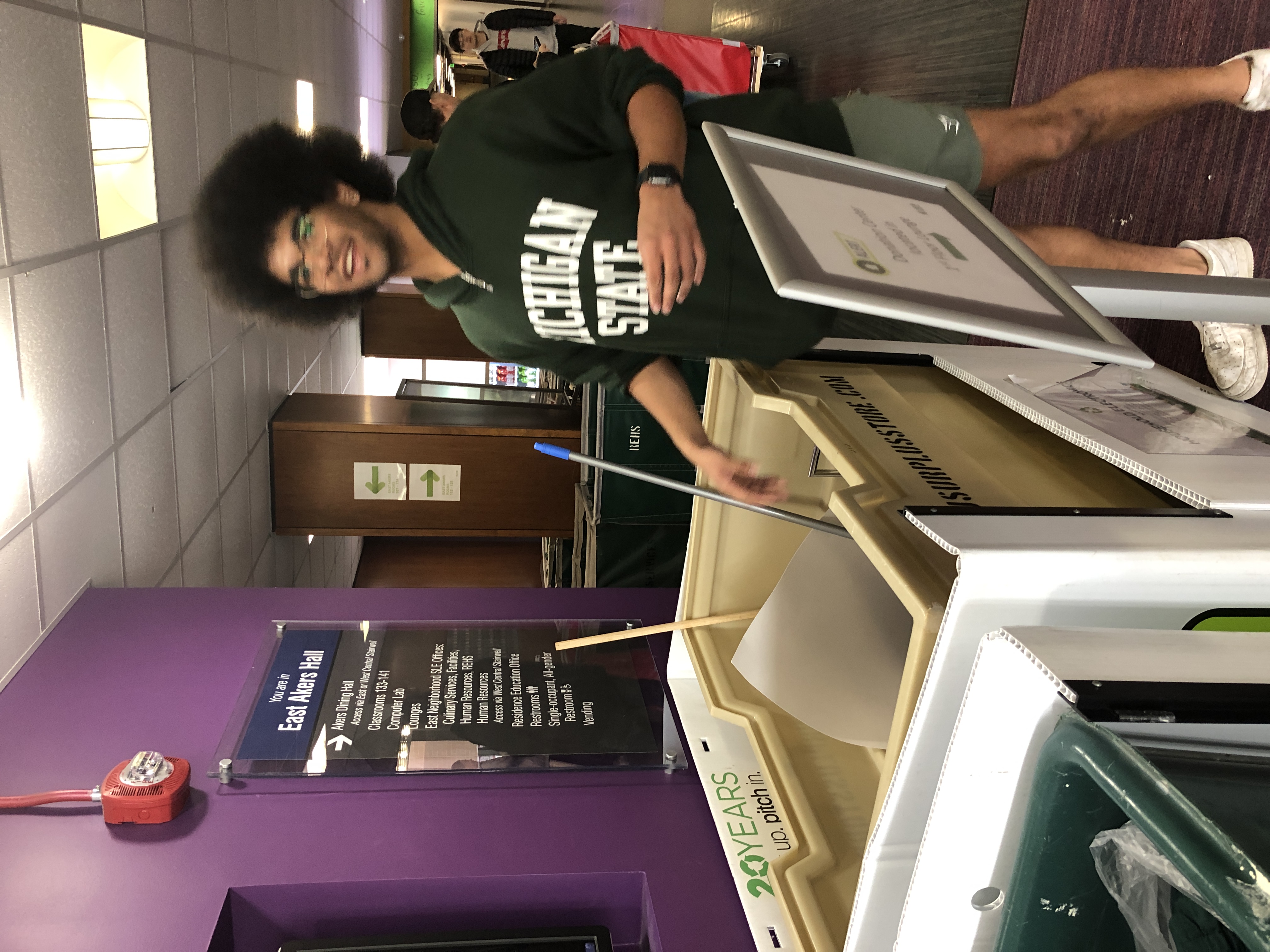 An MSU student stands by Pack Up. Pitch In. collection bins during the recent spring move-out.