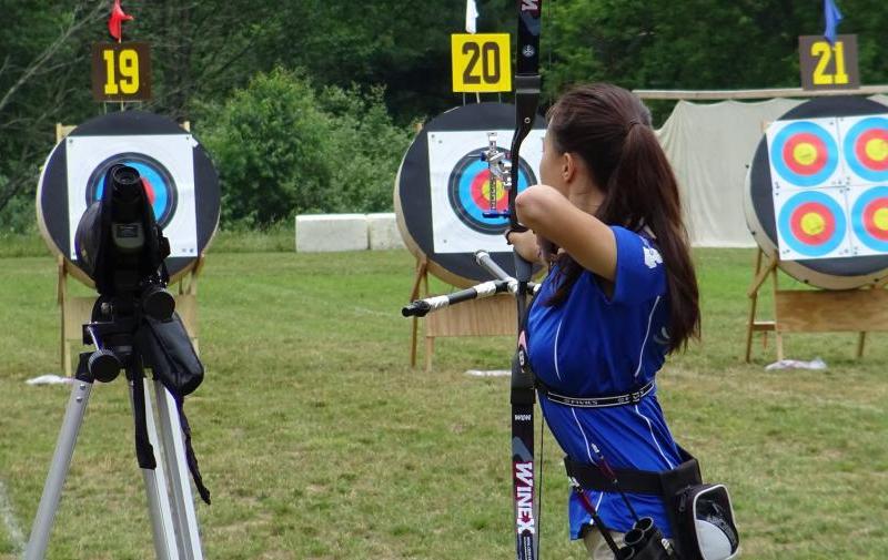 An archer aims downrange at a target, Demmer Center.