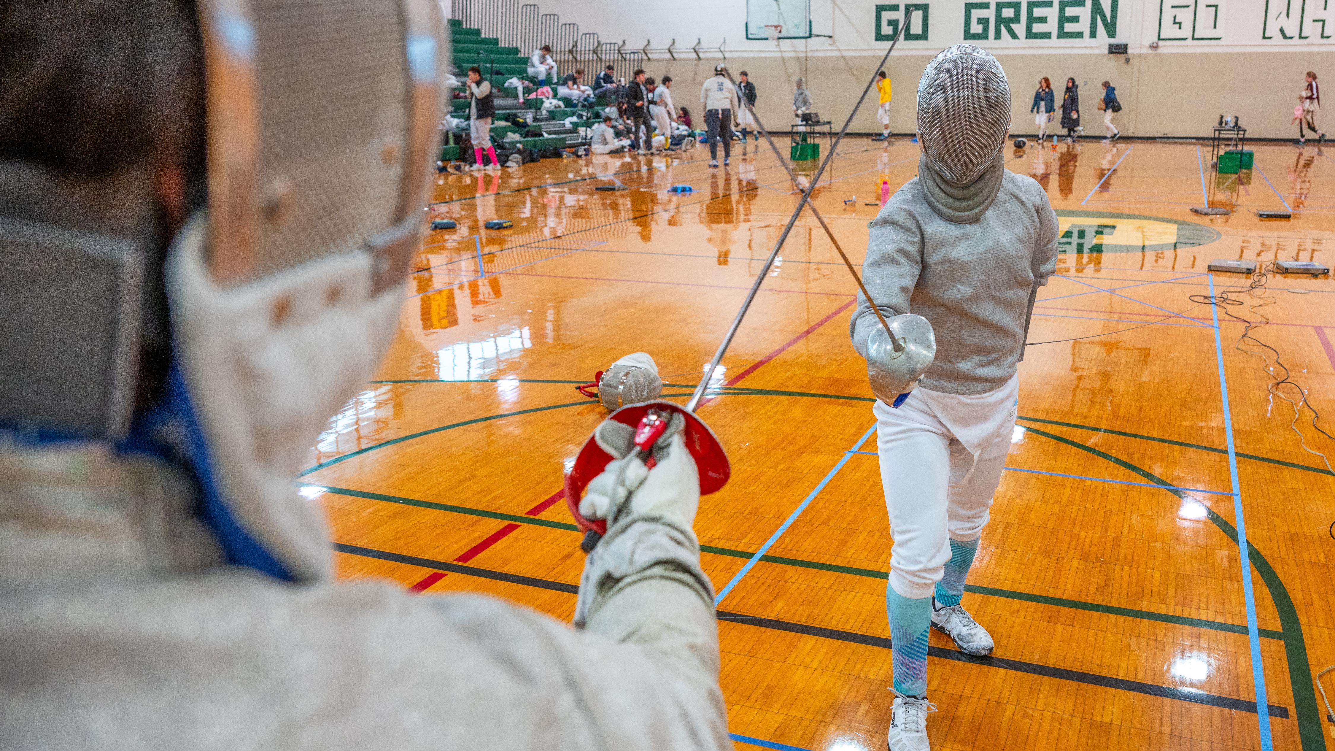 Students fencing in a gym