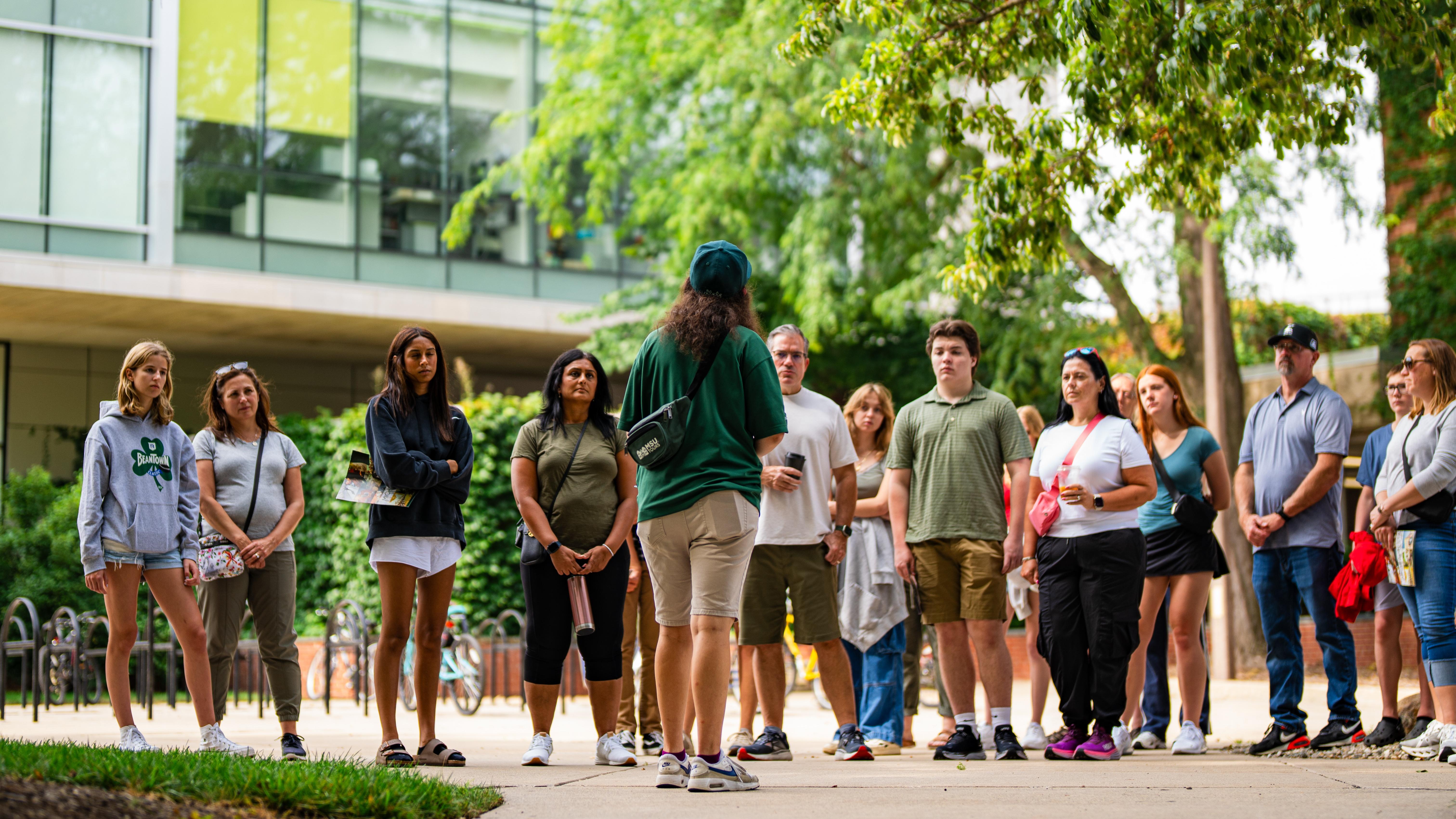 An MSU Tours student guide leads a group of visitors on a guided-tour on campus.