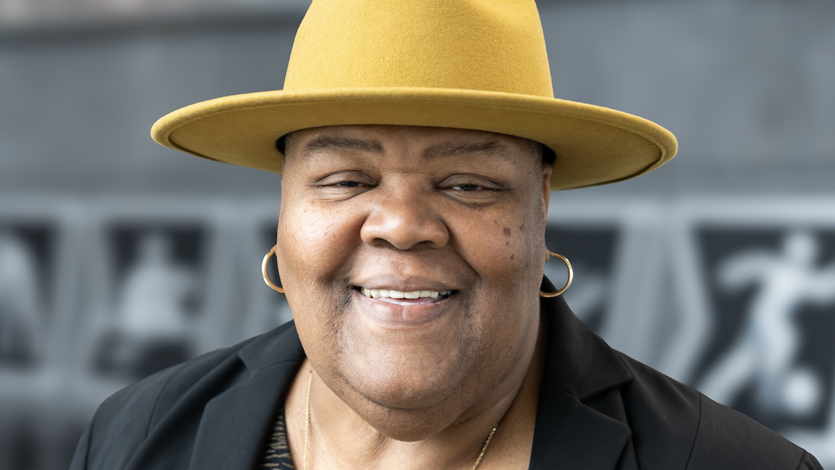A headshot of Culinary Services’ Brenda Nelson on campus wearing a hat and blazer.