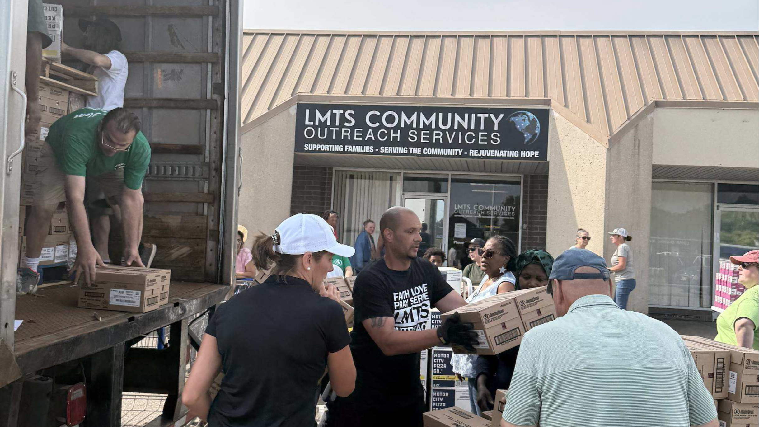 Team members unload boxes while setting up for a Fresh Food Friday event at LMTS Community Outreach Services.