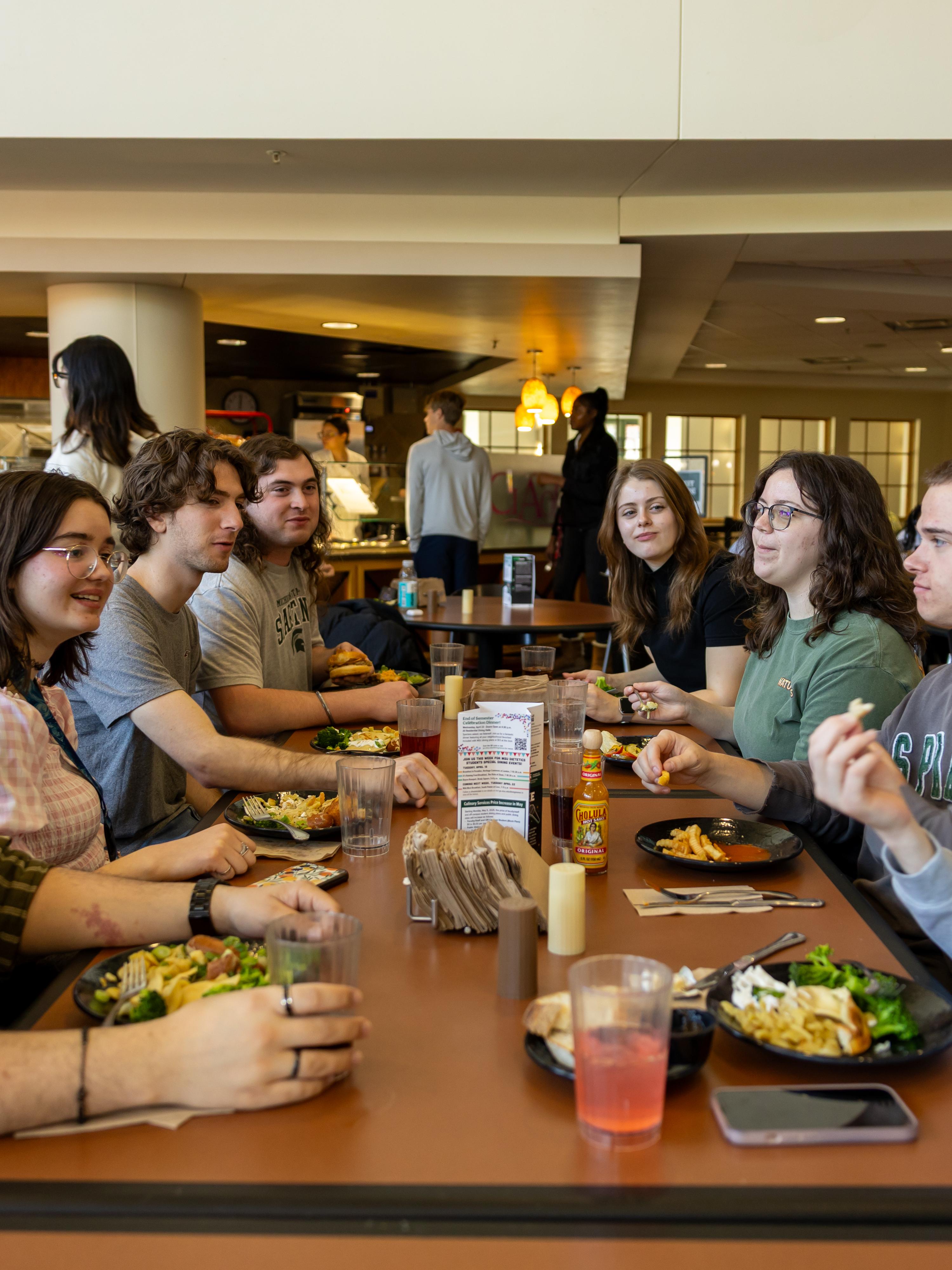 Students gathered around a dining hall table having a discussion